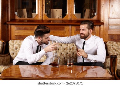 Two Friends Having A Glass Of Whiskey And A Nice Conversation