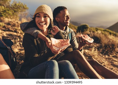 Two Friends Having Pizza Sitting On Mountain Trail. Man And Woman On Hiking Trip Eating Pizza.