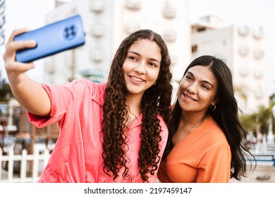 Two Friends Latin American Women With Brackets Taking A Photo Over Street.