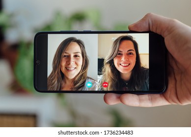 Two Friends Making A Video Call. Hand Holding Phone While Making A Video Call