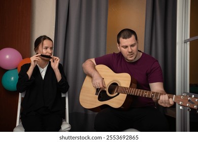 Two friends playing music together, musicians collaborating on a performance, playing guitar and harmonica, enjoying leisure time at home. - Powered by Shutterstock