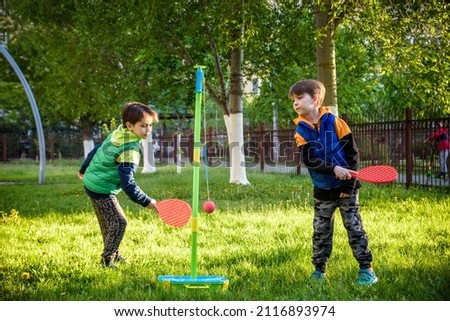 Two friends are playing tetherball swing ball game in summer camping. Two boy brother happy leisure healthy active time outdoors concept.
