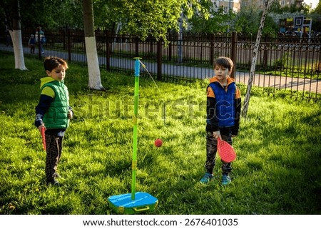 Two friends are playing tetherball swing ball game in summer camping. Two boy brother happy leisure healthy active time outdoors concept.