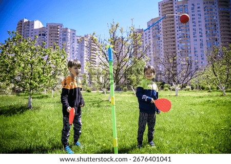 Two friends are playing tetherball swing ball game in summer camping. Two boy brother happy leisure healthy active time outdoors concept.