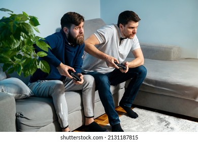 Two friends playing video games intensely , completive man playing video console 