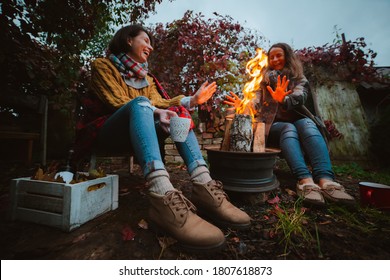 two friends relax comfortably and drink wine on an autumn evening in the open air by the fire in the backyard. The concept of autumn, friendship. top view of the legs - Powered by Shutterstock