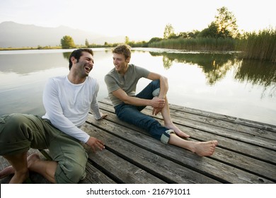 Two Friends Relaxing On The Pier.