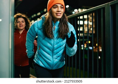 Two Friends Running And Exercising Outside At Night.