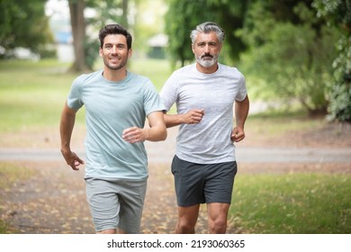 two friends running through the forest on a jogging trail - Shutterstock ID 2193060365