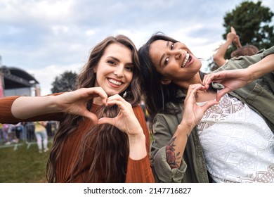 Two Friends Showing Heard Shape At The Music Festival  