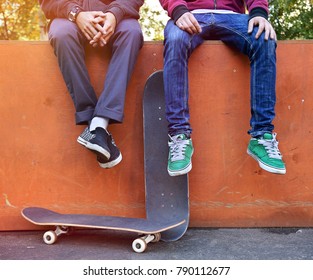 Two friends skateboarders in the skatepark rest after skating - Powered by Shutterstock