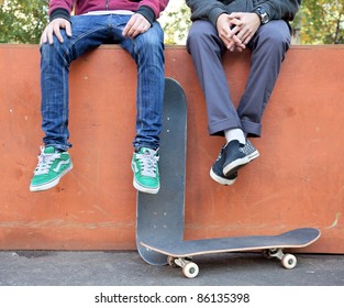 Two Friends Skateboarders In The Skatepark Rest After Skating