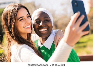 two friends smiling while taking selfie photo