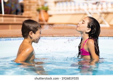 Two friends spitting water from mouth in a pool