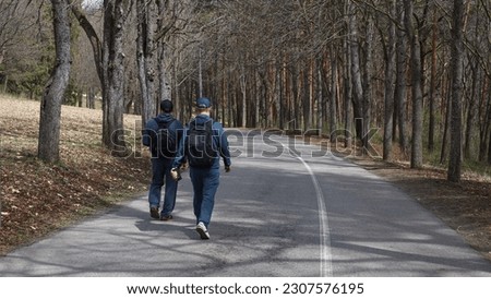 two friends in sport clothes walking in a city park