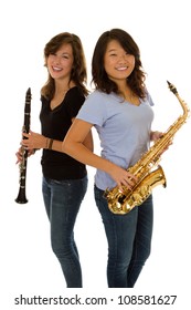 Two friends stand back to back with woodwind instruments