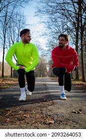 Two friends stretching their hamstring after running outside in the cold