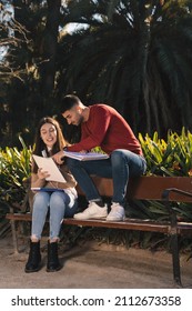 Two Friends Studying In The Park. Two Students Practicing For An Exam. Vertical Photograph, University Campus