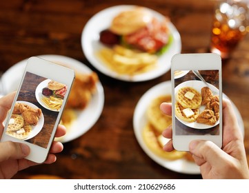 two friends taking photo of their food with smart phones