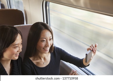 Two Friends Taking a Picture Out the Train Window