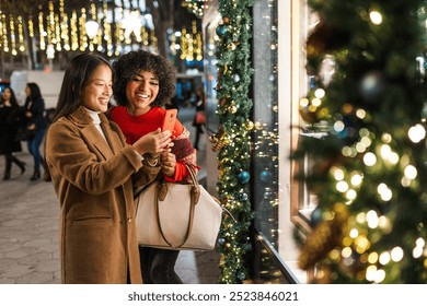 Two friends taking a selfie in front of a christmas shop window display - Powered by Shutterstock