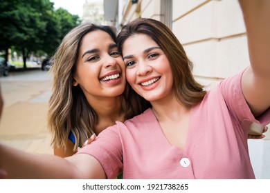 Two Friends Taking A Selfie Outdoors.