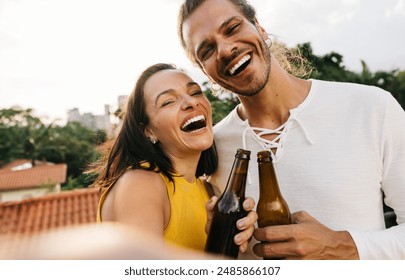 Two friends taking a selfie while enjoying drinks, smiling and having fun. Captures a happy moment with beers outdoors. - Powered by Shutterstock