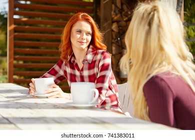 Zwei Freunde sprechen und trinken Kaffee auf der Terrasse