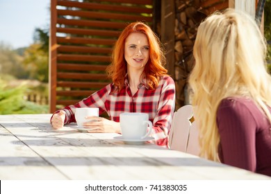 Zwei Freunde sprechen und trinken Kaffee auf der Terrasse