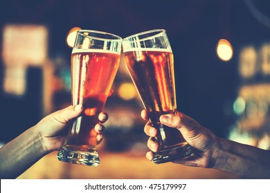 Zwei Freunde toasting mit Gläsern von leichtem Bier in der Kneipe. Schöner Hintergrund des Oktoberfests. feines Korn. Weicher Fokus. SCHLECHTER DOF. Blauer Ton