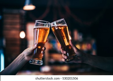 Zwei Freunde toasting mit Gläsern von leichtem Bier in der Kneipe. Schöner Hintergrund des Oktoberfests. feines Korn. Weicher Fokus. SCHLECHTER DOF.