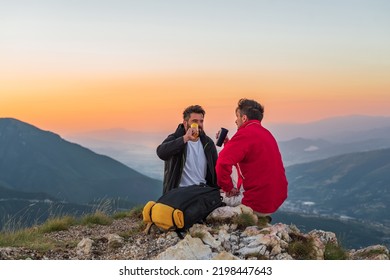 Two friends tourists are relaxing while drinking a cup of coffee during the hike on the mountain active healthy lifestyle adventure travel.	 - Shutterstock ID 2198447643