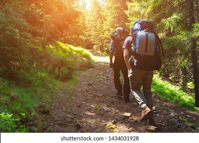 Two friends travel in the mountains with backpacks - Shutterstock ID 1434031928