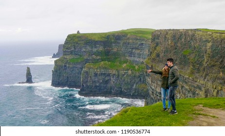 Two Friends Walk Along The Cliffs Of Moher