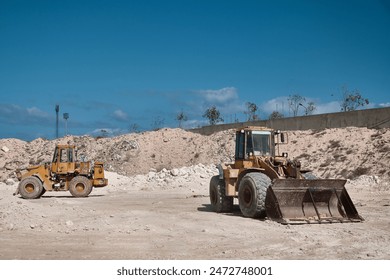 Two front loaders parked at limestone open pit mine. Earthmoving machnery. Loaders in a quarry