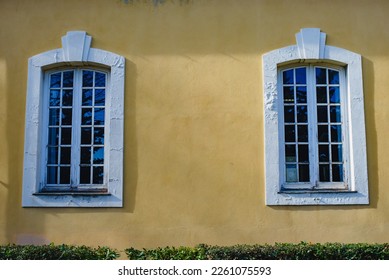 Two front windows on the yellow facade of the house - Shutterstock ID 2261075593