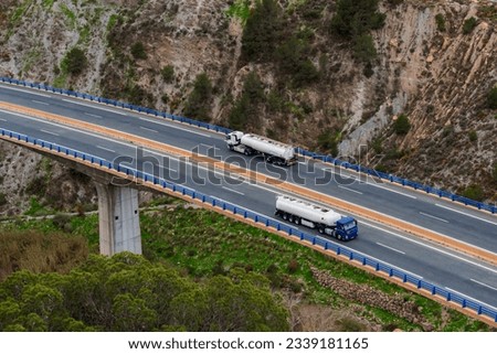 Similar – Foto Bild Zwei Tanklastzüge überqueren eine Autobahn über eine Brücke, Luftaufnahme.