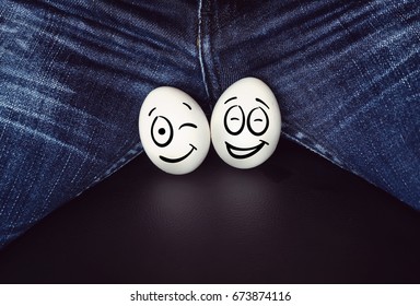 two funny eggs between the legs of a man. large chicken eggs as a symbol of male testicle.