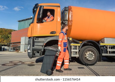 Two Garbagemen Working Together On Emptying Dustbins For Trash Removal