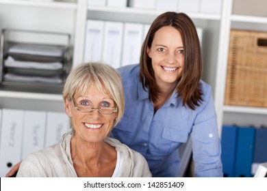 Two Generations, Younger And Older Cheerfully Posing Inside The Office.