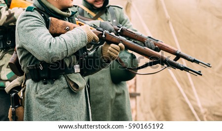 Two German soldier of the Second World War with Mauser rifles in their hands, ready to fire. Reconstruction