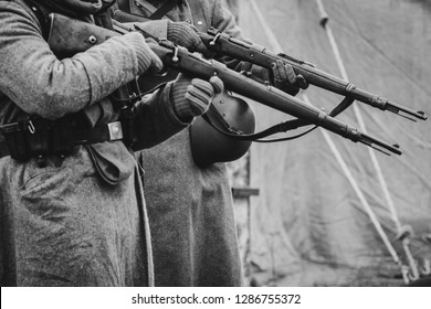 Two German Soldiers Of The Second World War With Rifles In Their Hands Ready To Fire. Black And White Photo