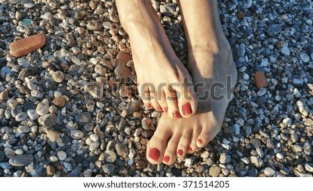 Two girl feet on a sunny gritty beach