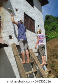 Two Girl Painting The Wall Of A House In Nepal