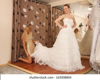 Two Girlfriends  - A Bride-To-Be And  Bridesmaid Trying On A Wedding Dress