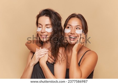 Two girlfriends are getting ready for double date, using under eye patches, healthcare procedure concept, copy space.