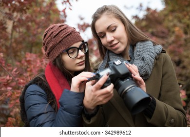 Two girlfriends looking into the camera for photos in park