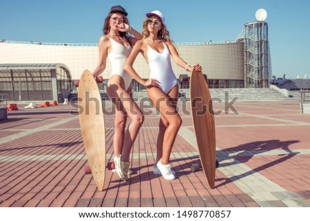 Similar – Image, Stock Photo Two women holding surfboard and looking at camera
