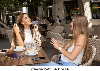 Two Girlfriends Talking In A Outside Cafe Bar