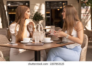 Two Girlfriends Talking In A Outside Cafe Bar